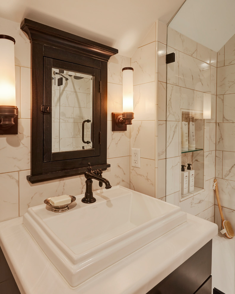 Design ideas for a small traditional bathroom in Milwaukee with shaker cabinets, dark wood cabinets, a drop-in tub, an alcove shower, a two-piece toilet, white tile, white walls, marble floors, a drop-in sink, solid surface benchtops, brown floor, marble and a hinged shower door.