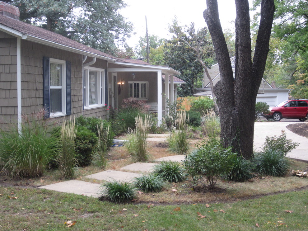 This is an example of a mid-sized front yard partial sun driveway in Kansas City with a garden path and mulch.