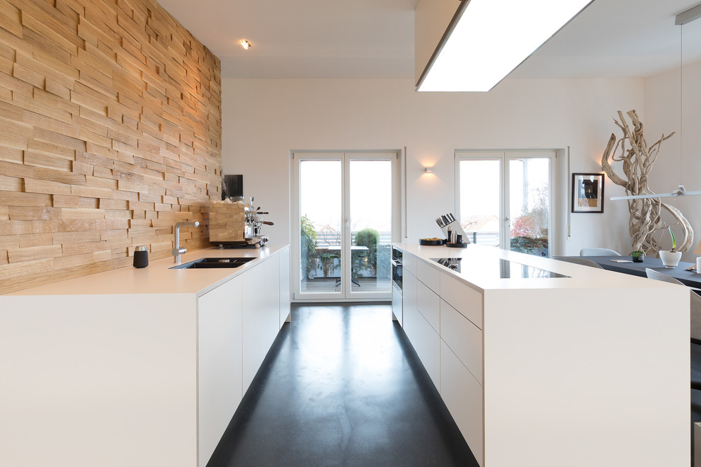 Mid-sized contemporary galley open plan kitchen in Stuttgart with a double-bowl sink, flat-panel cabinets, white cabinets, laminate benchtops, brown splashback, timber splashback, black appliances, slate floors, multiple islands, black floor and white benchtop.