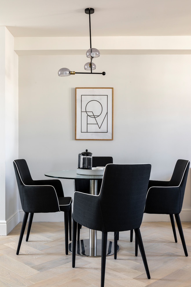 Modern dining room in London with white walls, light hardwood floors and beige floor.