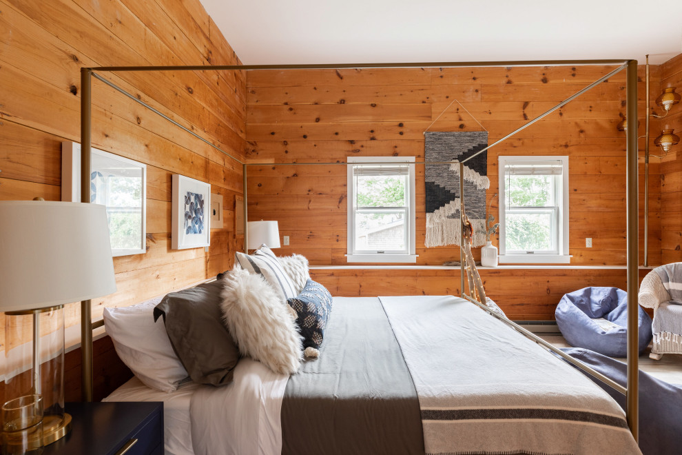 Photo of a large industrial master bedroom in Portland Maine with brown walls, carpet, beige floors and wood walls.