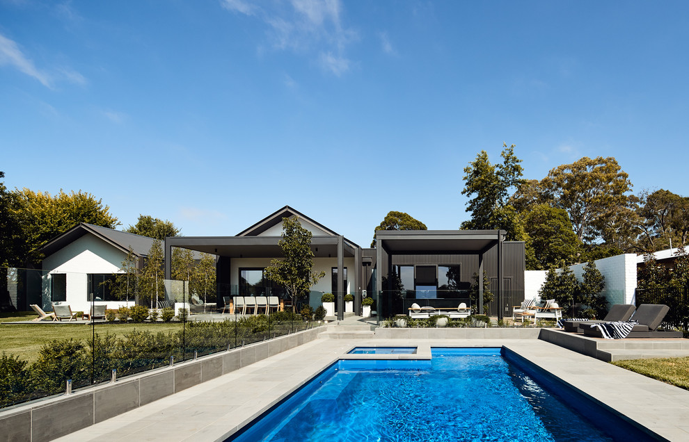 Design ideas for a mid-sized contemporary backyard rectangular lap pool in Melbourne with natural stone pavers.