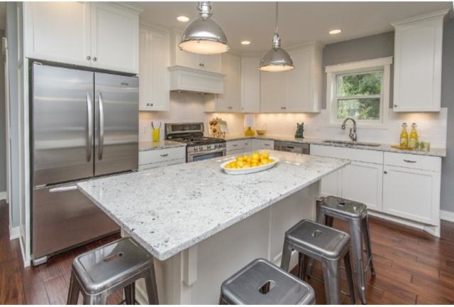 This is an example of a small arts and crafts l-shaped open plan kitchen in Minneapolis with an undermount sink, shaker cabinets, white cabinets, granite benchtops, white splashback, subway tile splashback, stainless steel appliances, dark hardwood floors and with island.