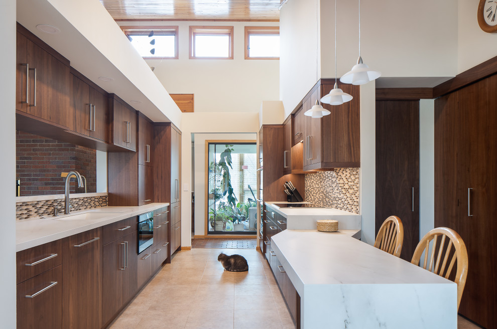 Inspiration for a mid-sized modern galley vinyl floor, beige floor and wood ceiling eat-in kitchen remodel in Minneapolis with an undermount sink, flat-panel cabinets, dark wood cabinets, marble countertops, multicolored backsplash, glass tile backsplash, stainless steel appliances and white countertops