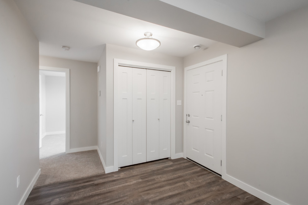 Front door - mid-sized transitional medium tone wood floor front door idea in Calgary with gray walls and a white front door