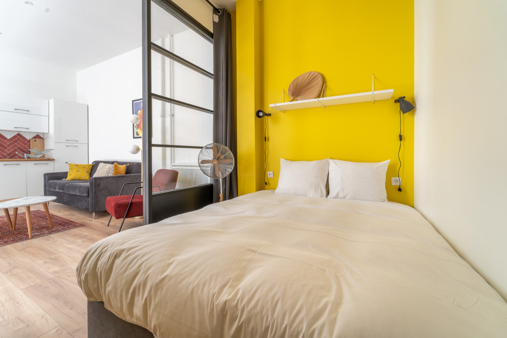 На фото: спальня в современном стиле с желтыми стенами, светлым паркетным полом и бежевым полом