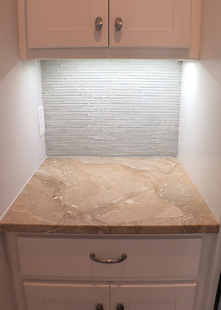 Large transitional eat-in kitchen photo with white cabinets, marble countertops, white backsplash, glass sheet backsplash and an island