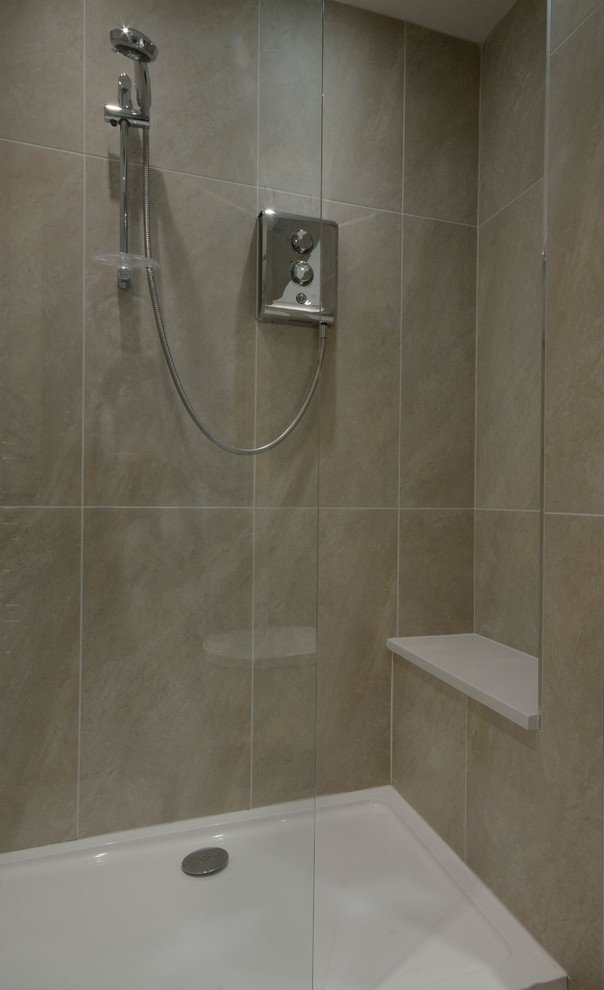 This is an example of a mid-sized country 3/4 bathroom in Dublin with an integrated sink, furniture-like cabinets, light wood cabinets, a double shower, a wall-mount toilet, brown tile, porcelain tile, brown walls and porcelain floors.