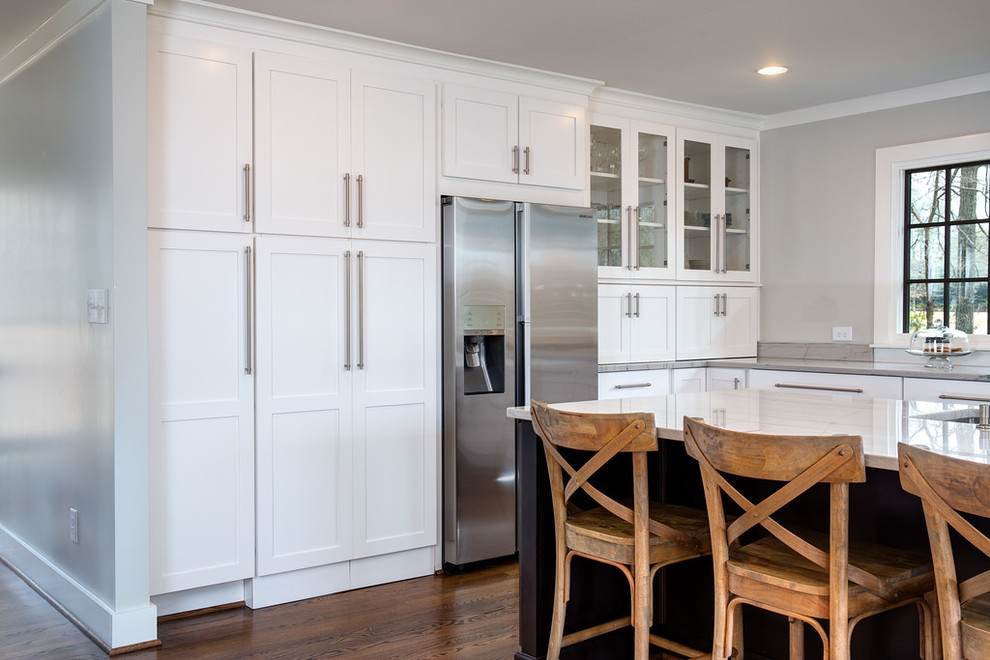 Example of a huge transitional u-shaped medium tone wood floor eat-in kitchen design in Birmingham with an undermount sink, shaker cabinets, white cabinets, marble countertops, gray backsplash, subway tile backsplash, stainless steel appliances and an island