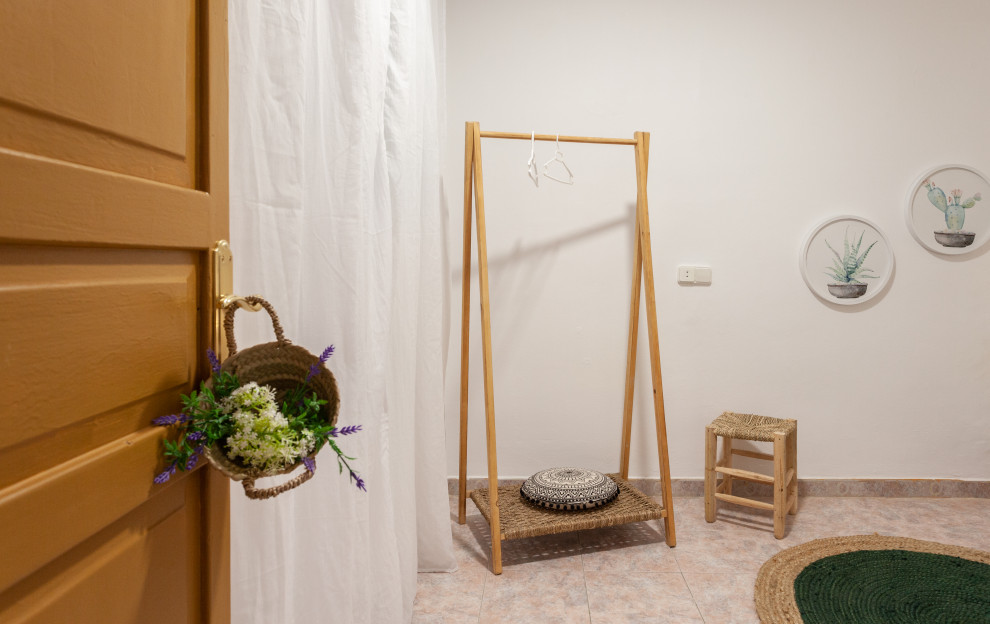 Ejemplo de dormitorio principal y beige y rosa mediterráneo de tamaño medio con paredes blancas y suelo rosa