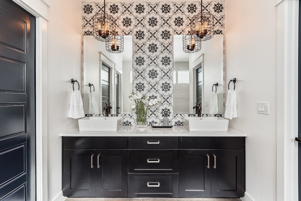 This is an example of a country master bathroom in Boise with shaker cabinets, black cabinets, a drop-in tub, black and white tile, cement tile, white walls, porcelain floors, a vessel sink and engineered quartz benchtops.