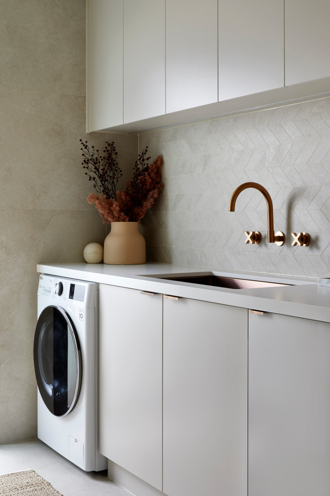 Idéer för små funkis parallella vitt tvättstugor enbart för tvätt och med garderob, med en undermonterad diskho, grå skåp, bänkskiva i kvarts, beige stänkskydd, stänkskydd i mosaik, beige väggar, klinkergolv i porslin och beiget golv