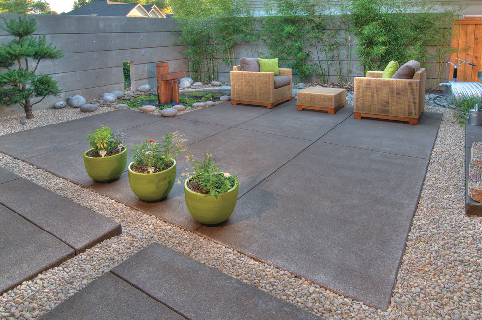 Small transitional courtyard patio in Other with a water feature, concrete slab and a roof extension.