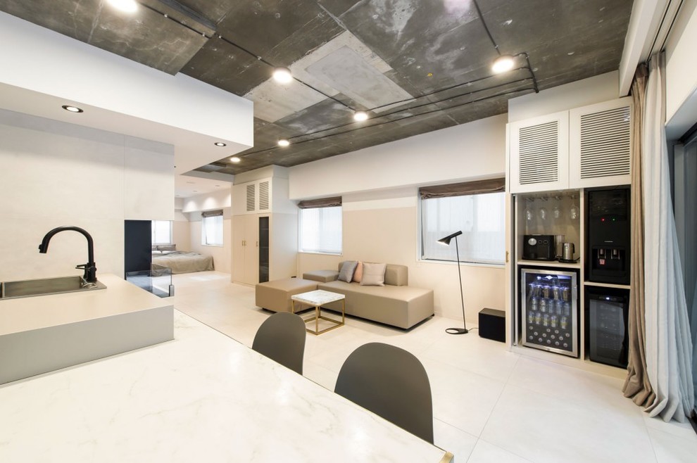 This is an example of an industrial open concept living room in Tokyo with grey walls and white floor.