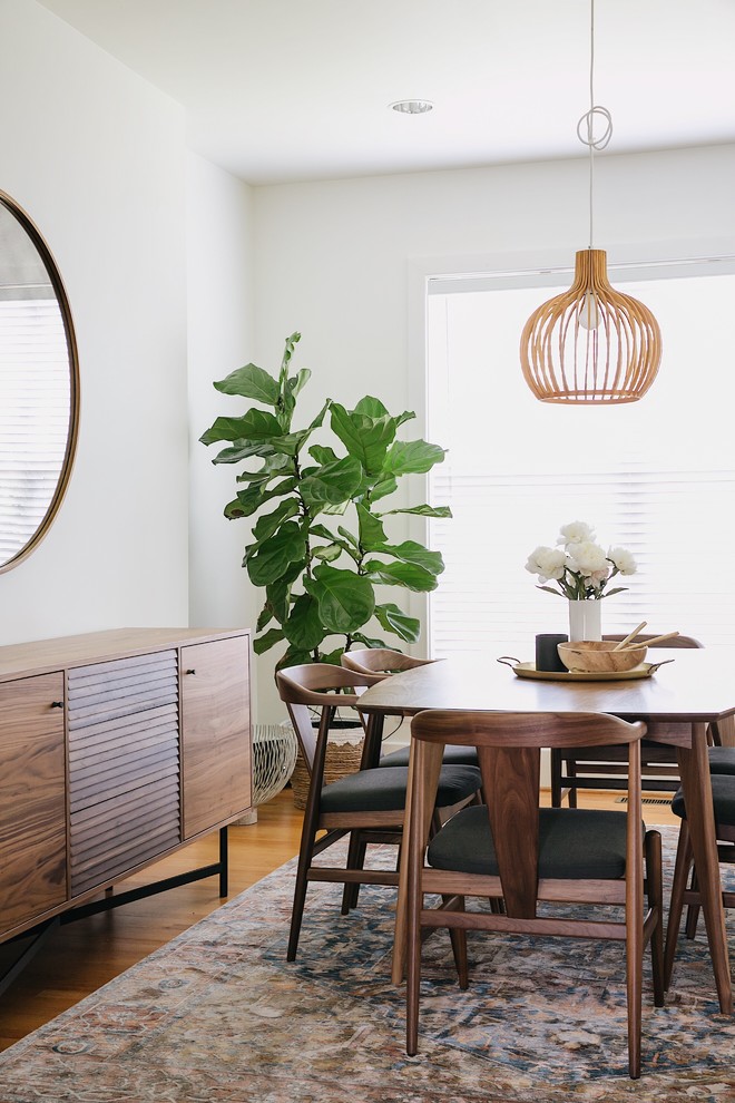 Inspiration for a midcentury dining room in Nashville with white walls, medium hardwood floors and no fireplace.