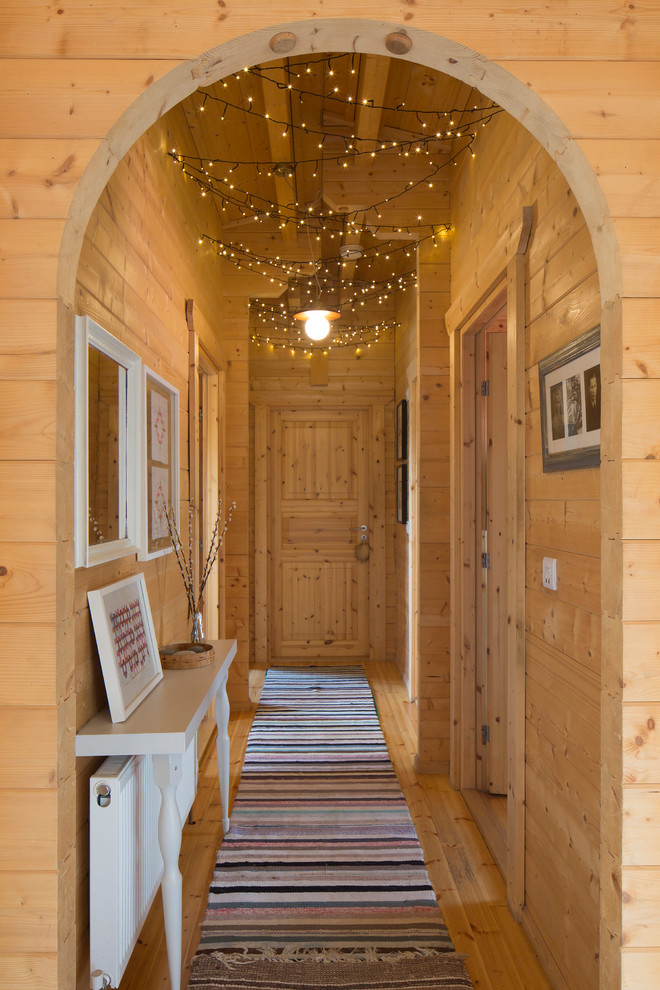 Small country hallway in Buckinghamshire with light hardwood floors, beige walls and beige floor.