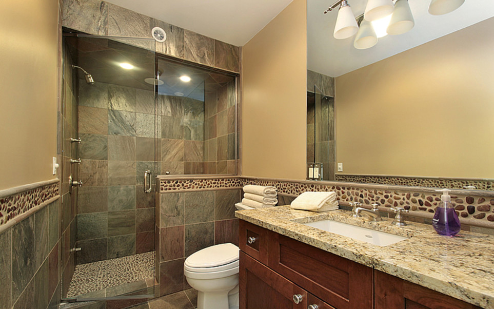 Photo of a small traditional 3/4 bathroom in Philadelphia with shaker cabinets, medium wood cabinets, a drop-in tub, a corner shower, a two-piece toilet, beige tile, pebble tile, white walls, ceramic floors, an undermount sink, solid surface benchtops, beige floor and a hinged shower door.