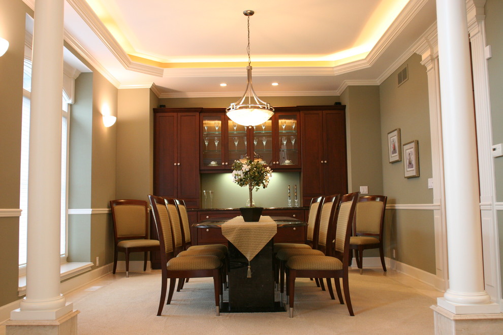 This is an example of a large traditional separate dining room in New York with green walls and carpet.