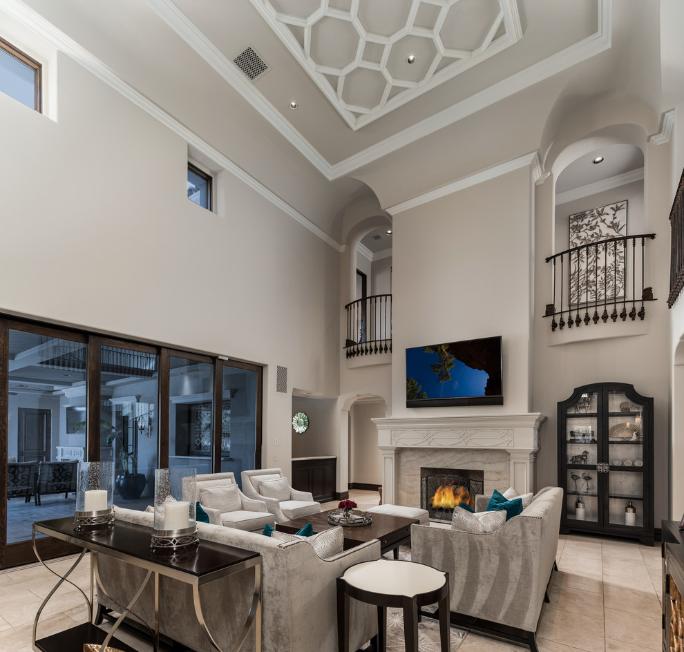 This is an example of an expansive mediterranean open concept family room in Phoenix with white walls, marble floors, a standard fireplace, a stone fireplace surround, no tv, multi-coloured floor, coffered and panelled walls.