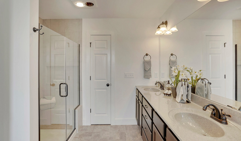 Inspiration for a mid-sized traditional master bathroom in Other with dark wood cabinets, a freestanding tub, an alcove shower, beige walls, ceramic floors, an integrated sink, granite benchtops, a hinged shower door and beige benchtops.