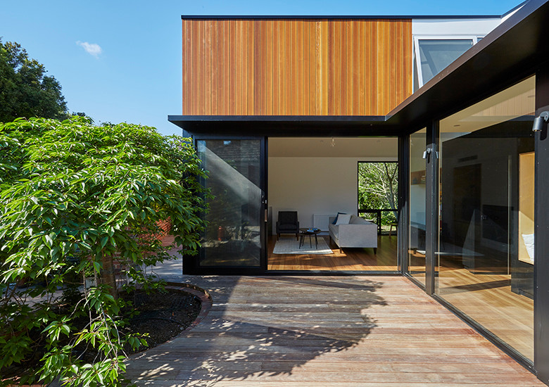 Small contemporary one-storey exterior in Melbourne with wood siding.