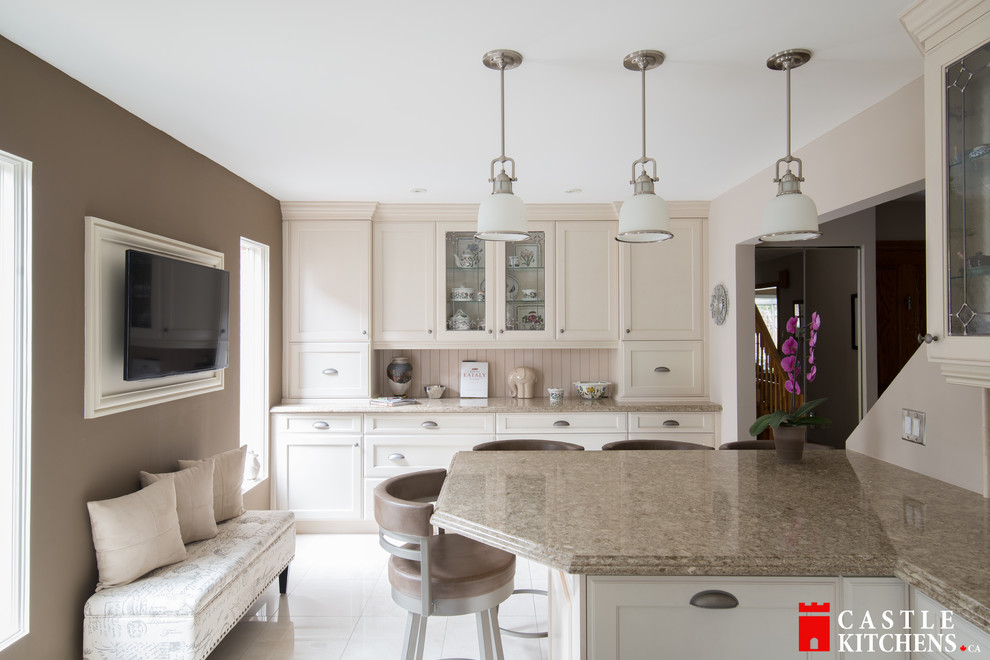 Example of a mid-sized transitional galley porcelain tile enclosed kitchen design in Toronto with an undermount sink, shaker cabinets, beige cabinets, quartzite countertops, beige backsplash, stainless steel appliances and an island