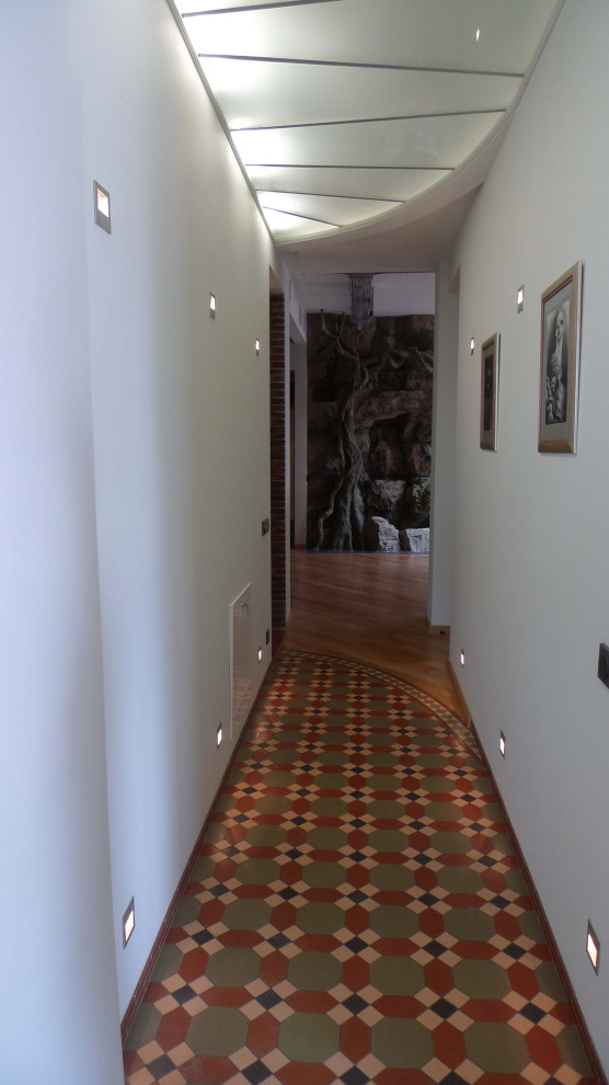 Идея дизайна: большой, узкий коридор в стиле лофт с полом из керамической плитки, многоуровневым потолком, белыми стенами, обоями на стенах и коричневым полом