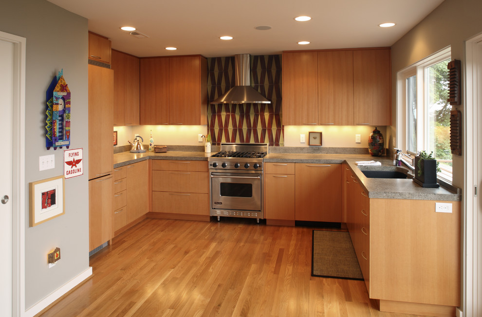 Design ideas for a contemporary u-shaped kitchen in Portland with flat-panel cabinets and medium wood cabinets.