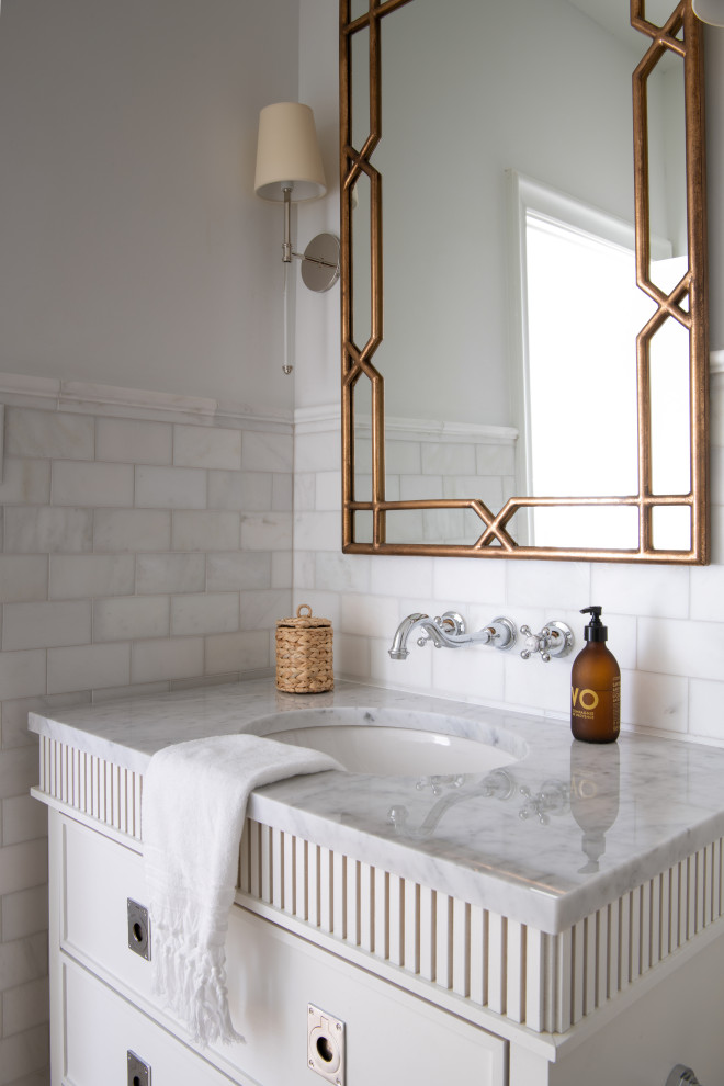 Свежая идея для дизайна: большая ванная комната в стиле неоклассика (современная классика) с фасадами островного типа, белыми фасадами, полновстраиваемой ванной, раздельным унитазом, белой плиткой, мраморной плиткой, белыми стенами, светлым паркетным полом, врезной раковиной, мраморной столешницей, коричневым полом, душем с распашными дверями, белой столешницей, сиденьем для душа, тумбой под одну раковину и напольной тумбой - отличное фото интерьера