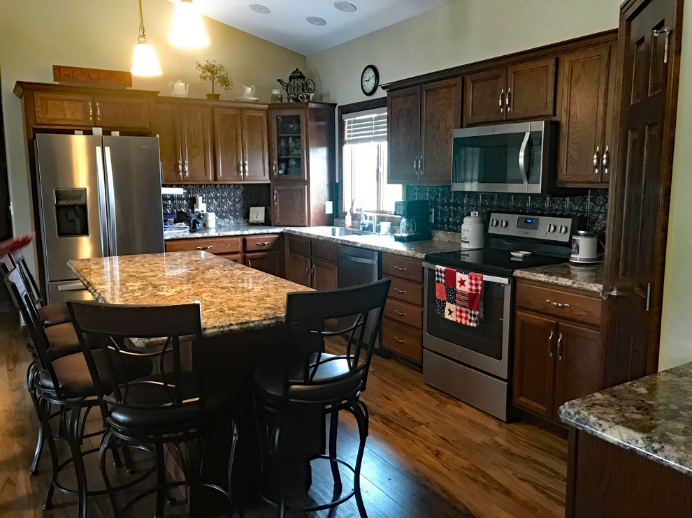 Brown floor kitchen photo with brown cabinets, brown backsplash, an island and brown countertops