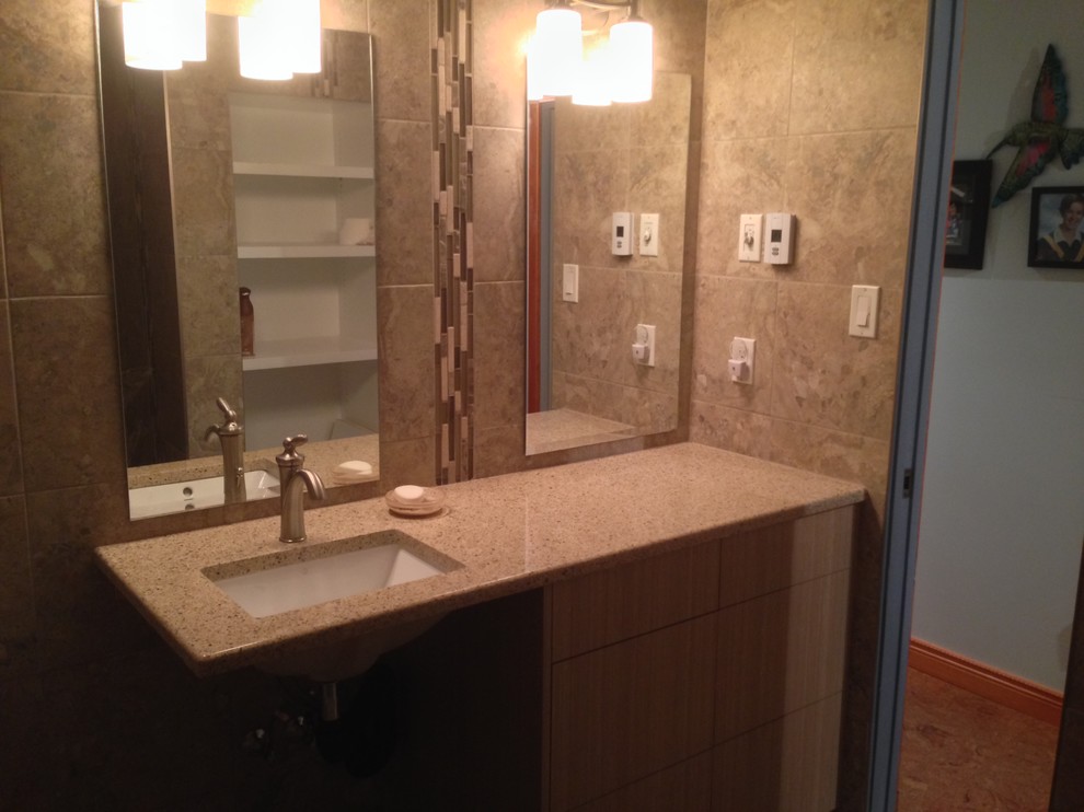 This is an example of a small contemporary 3/4 bathroom in Vancouver with flat-panel cabinets, light wood cabinets, gray tile, pebble tile, engineered quartz benchtops, an open shower, a two-piece toilet, brown walls, pebble tile floors, an undermount sink, multi-coloured floor and an open shower.