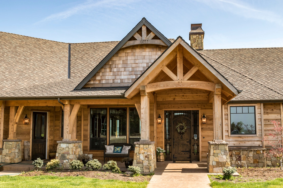 Photo of a large country one-storey brown house exterior in Portland with stone veneer, a gable roof and a shingle roof.