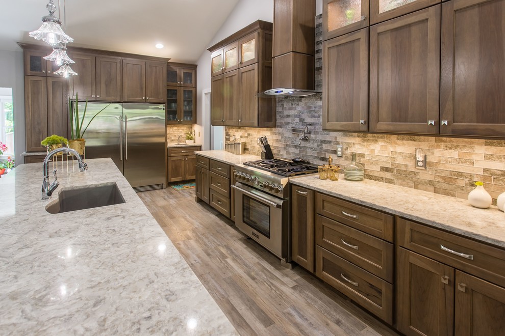 Open concept kitchen - transitional l-shaped open concept kitchen idea with shaker cabinets, stainless steel appliances and an island