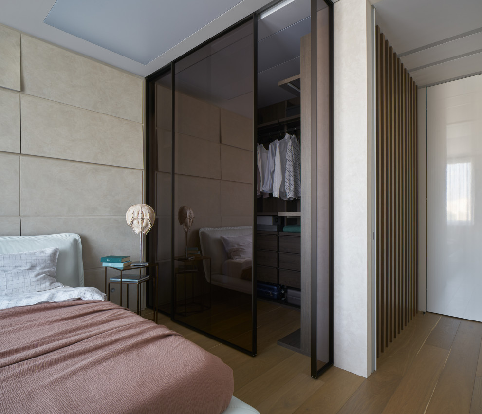 Modelo de dormitorio principal actual con paredes beige y suelo marrón