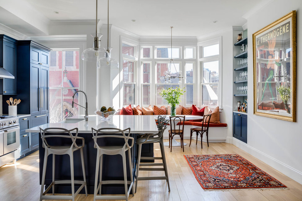 Inspiration for a transitional light wood floor eat-in kitchen remodel in Boston with blue cabinets, stainless steel appliances, an island, white countertops, a farmhouse sink and shaker cabinets