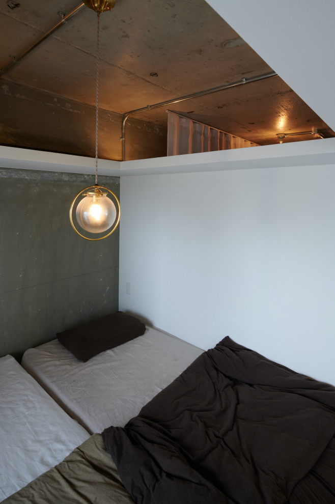 Kleines Industrial Schlafzimmer mit grauer Wandfarbe, braunem Holzboden, braunem Boden, freigelegten Dachbalken und Holzdielenwänden in Tokio