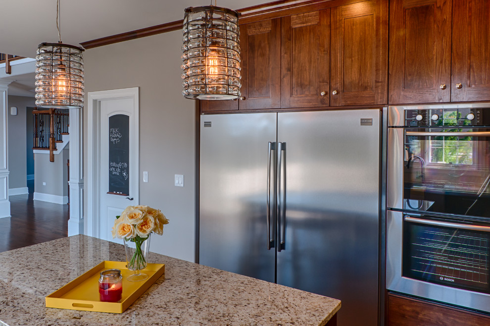 Mid-sized transitional u-shaped dark wood floor eat-in kitchen photo in Chicago with a farmhouse sink, recessed-panel cabinets, medium tone wood cabinets, granite countertops, beige backsplash, ceramic backsplash, stainless steel appliances and an island