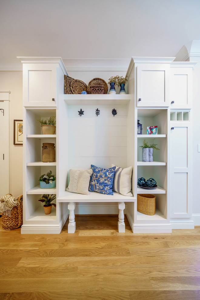 Inspiration for a large transitional medium tone wood floor and brown floor mudroom remodel with white walls and a medium wood front door