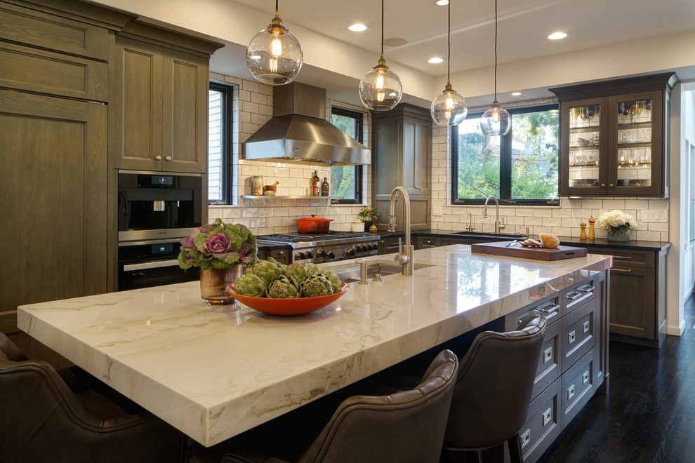 Large transitional l-shaped eat-in kitchen in Chicago with an undermount sink, flat-panel cabinets, medium wood cabinets, quartzite benchtops, white splashback, ceramic splashback, panelled appliances, dark hardwood floors, with island, brown floor and white benchtop.