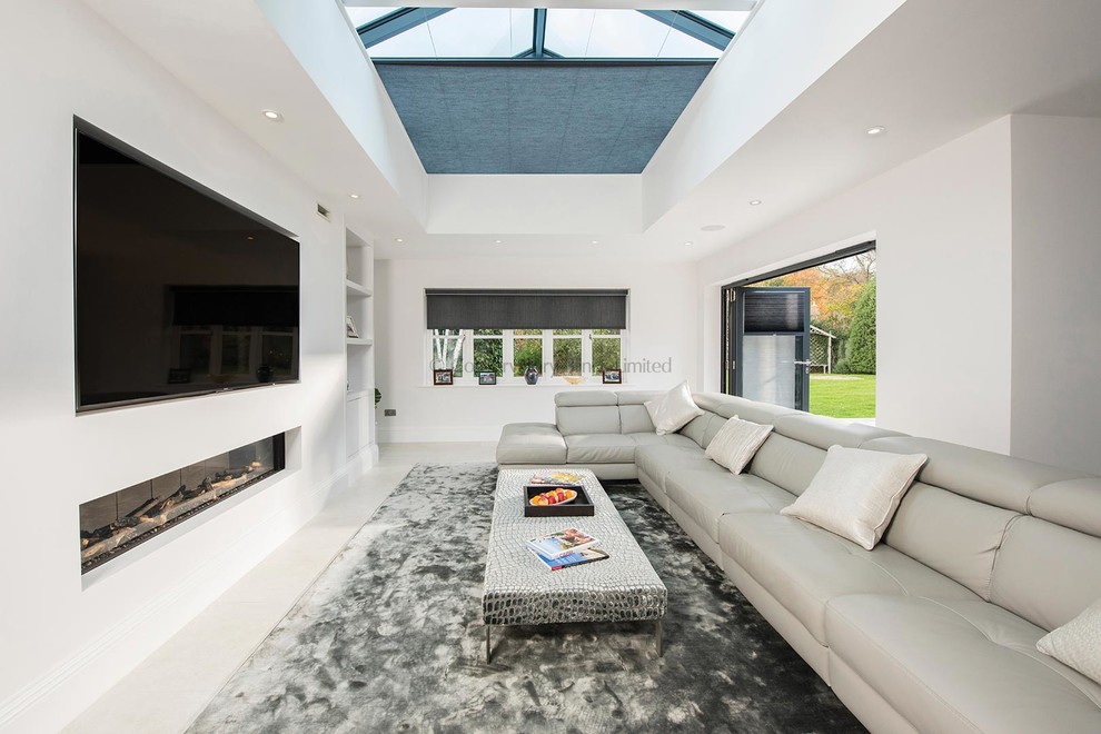 This is an example of a large contemporary open plan dining in Buckinghamshire with white walls, carpet, a ribbon fireplace, a plaster fireplace surround and grey floor.