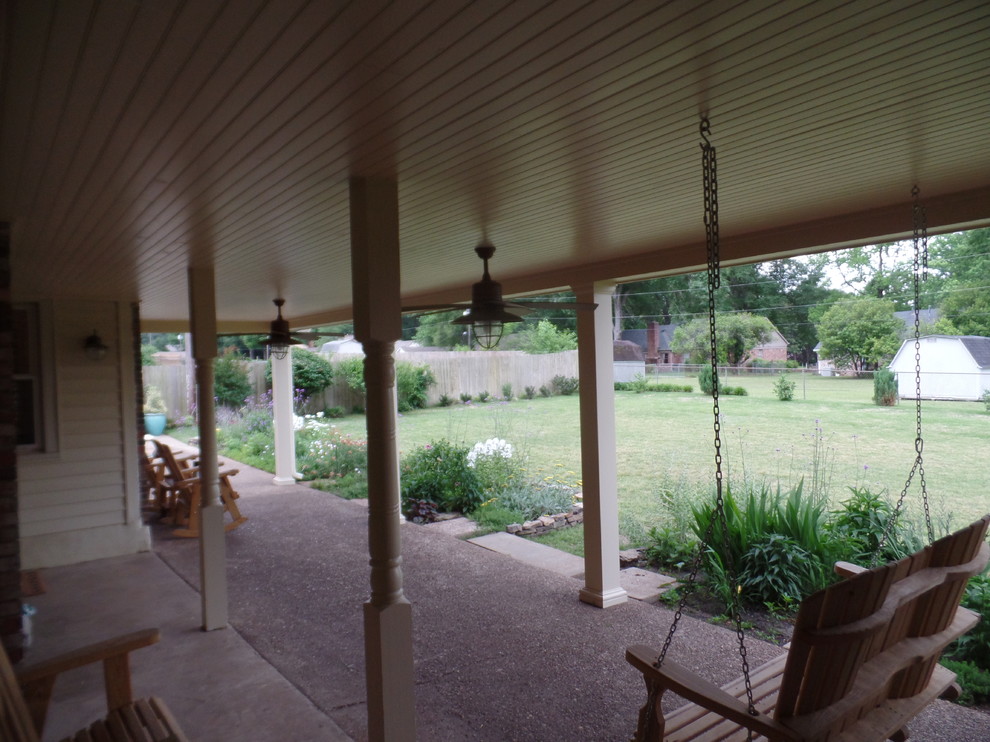 This is an example of a large traditional backyard verandah in Other with a roof extension.
