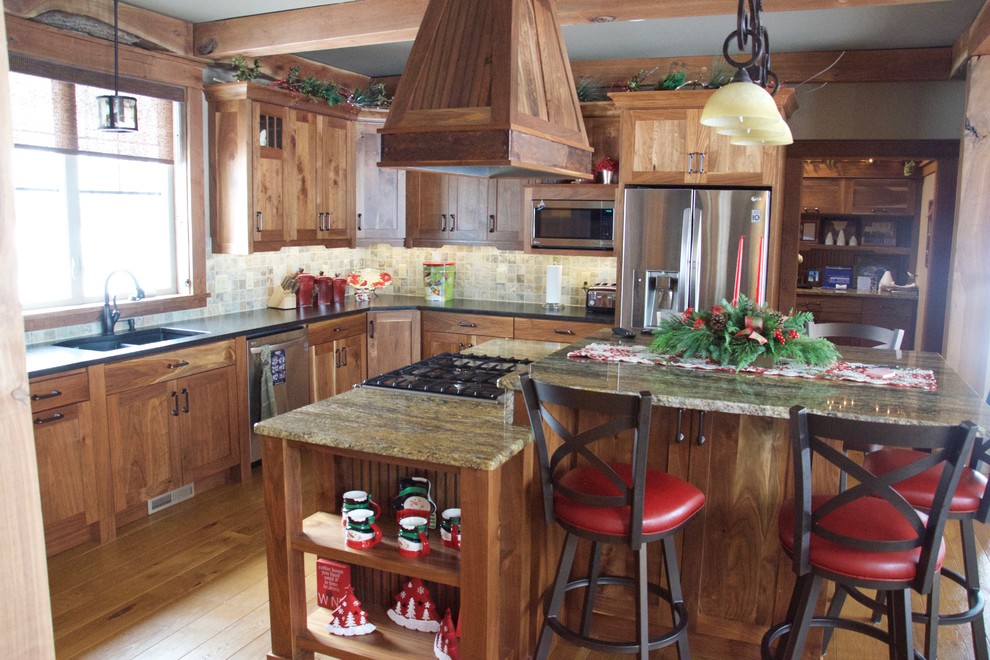 Example of a mountain style eat-in kitchen design in Minneapolis with recessed-panel cabinets, medium tone wood cabinets and an island