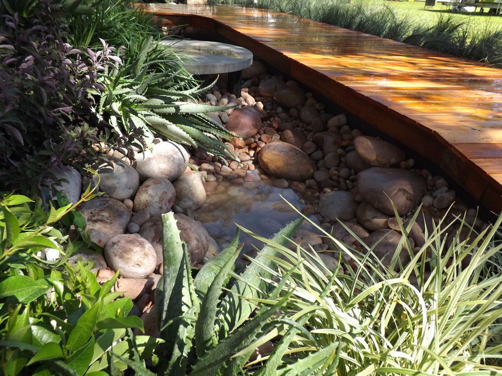 Small contemporary courtyard garden in Perth with a water feature and decking.