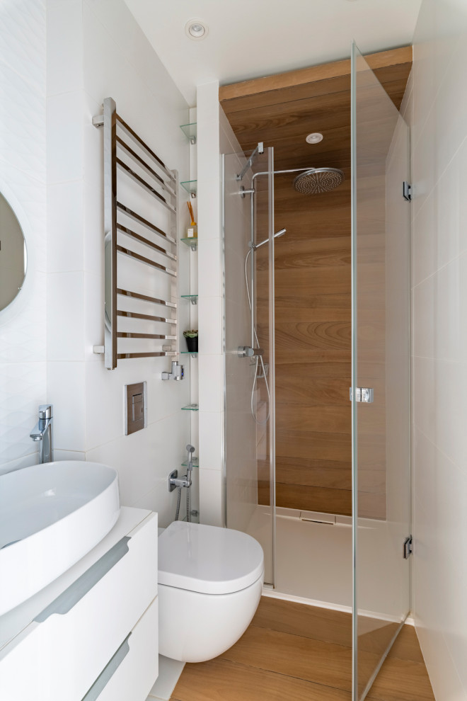 Inspiration for a medium sized contemporary shower room bathroom in Other with flat-panel cabinets, white cabinets, a built-in shower, a wall mounted toilet, white tiles, porcelain tiles, white walls, porcelain flooring, a wall-mounted sink, brown floors, a hinged door, a single sink and a floating vanity unit.