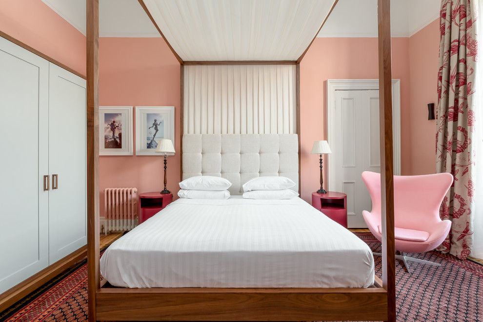 This is an example of a traditional master bedroom in Edinburgh with pink walls.