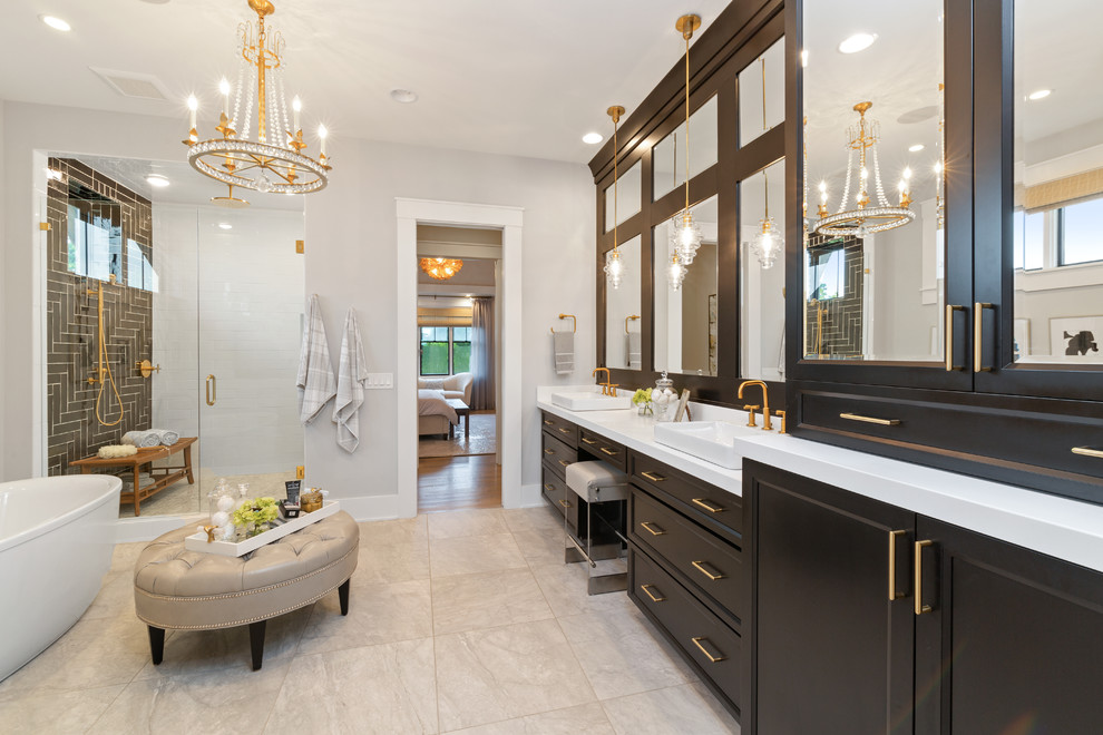 Design ideas for a country master bathroom in Cincinnati with recessed-panel cabinets, black cabinets, a freestanding tub, grey walls, a vessel sink, grey floor and white benchtops.