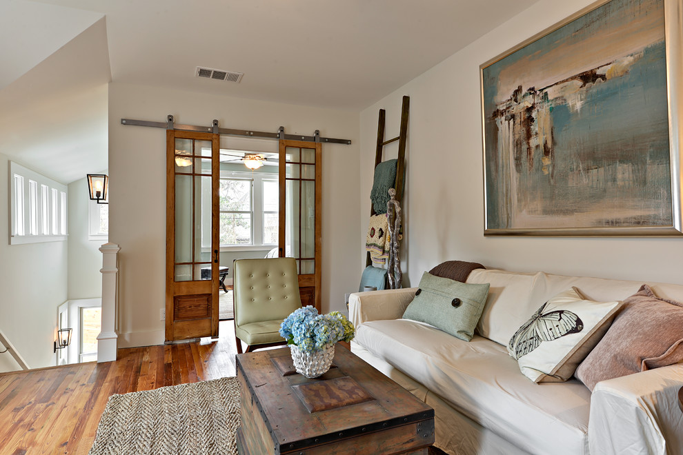 Example of a transitional loft-style living room design in Austin with white walls and no fireplace