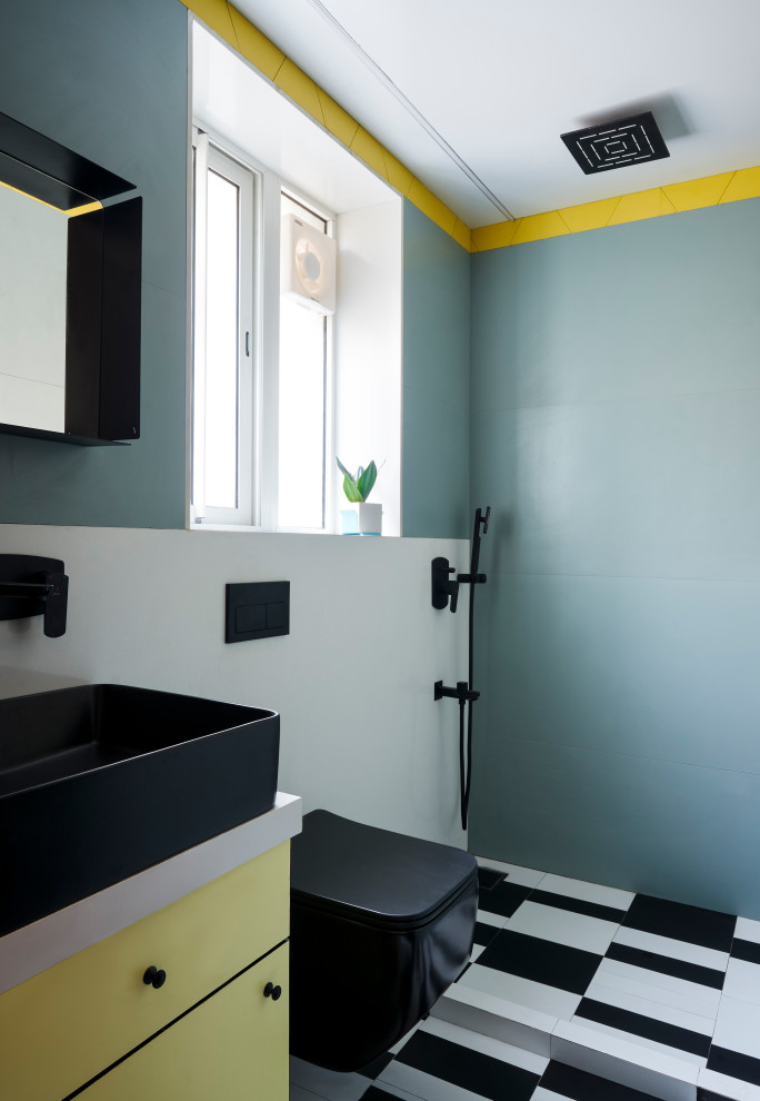 This is an example of a small midcentury master bathroom in Mumbai with flat-panel cabinets, yellow cabinets, a wall-mount toilet, blue tile, porcelain tile, blue walls, porcelain floors, a vessel sink, engineered quartz benchtops, multi-coloured floor, white benchtops, a single vanity and a floating vanity.
