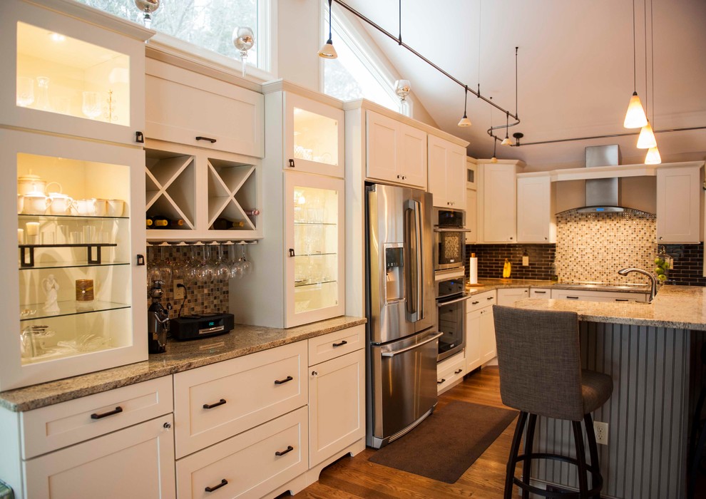 Mid-sized transitional single-wall medium tone wood floor eat-in kitchen photo in Boston with a single-bowl sink, recessed-panel cabinets, white cabinets, granite countertops, black backsplash, stainless steel appliances and an island