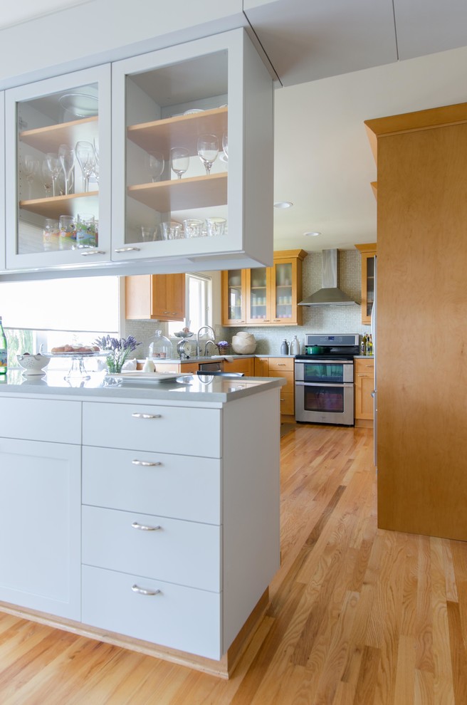 Mid-sized transitional u-shaped light wood floor eat-in kitchen photo in Seattle with an undermount sink, shaker cabinets, light wood cabinets, quartz countertops, mosaic tile backsplash, stainless steel appliances and a peninsula